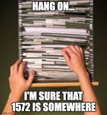 Image of a cluttered filing cabinet with the text "Hang on... I'm sure that 1572 is somewhere"